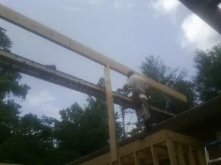 Carpenter setting a ridge beam over a new addition frame — Ice Dam Removal by Roofing Brothers in Linwood